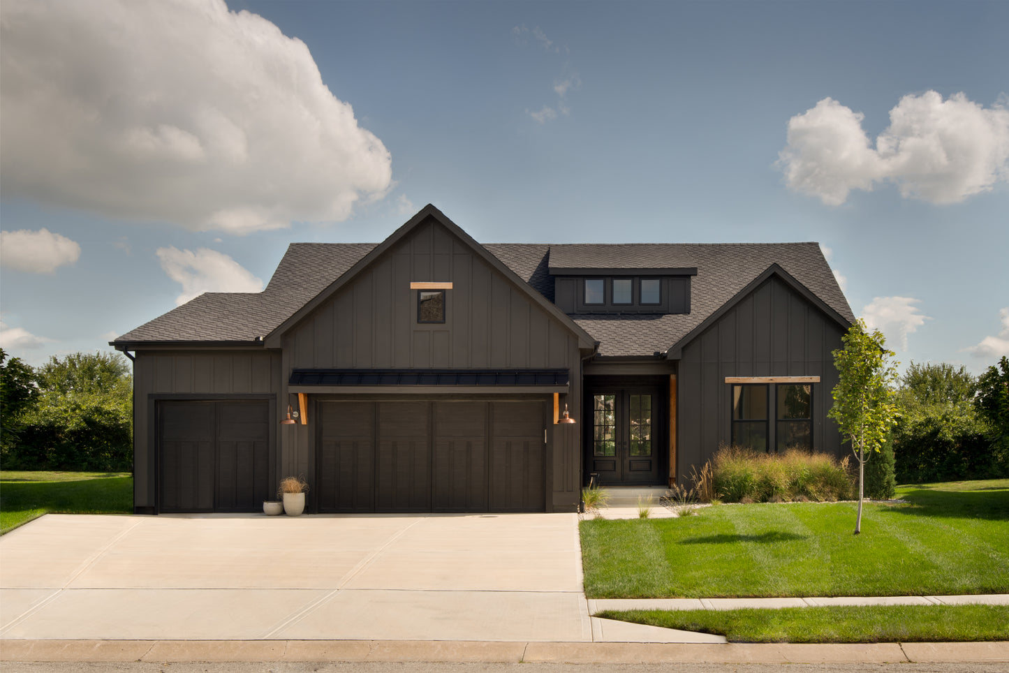 A black front exterior of a custom home built in the modern farmhouse style of architecture.