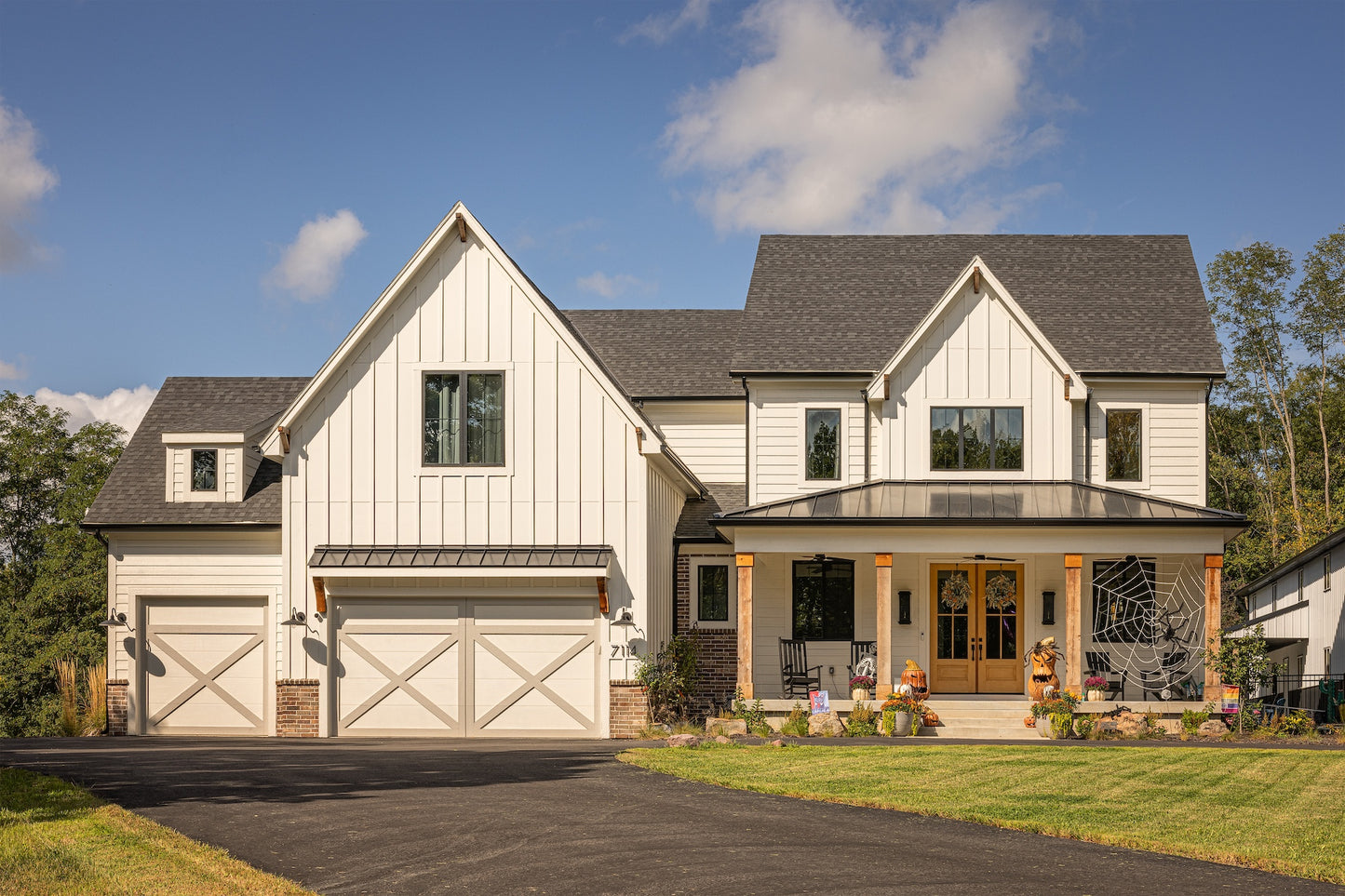 A front view of a modern farmhouse custom home with a green lawn.