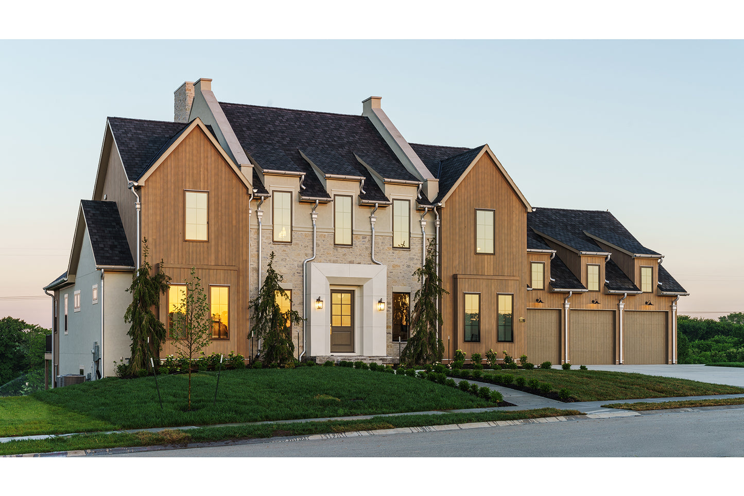 European and modern cottage style of architecture custom home with front lawn and landscaping.