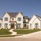 Front of a European and French Country style of custom home with front lawn and lancscaping.